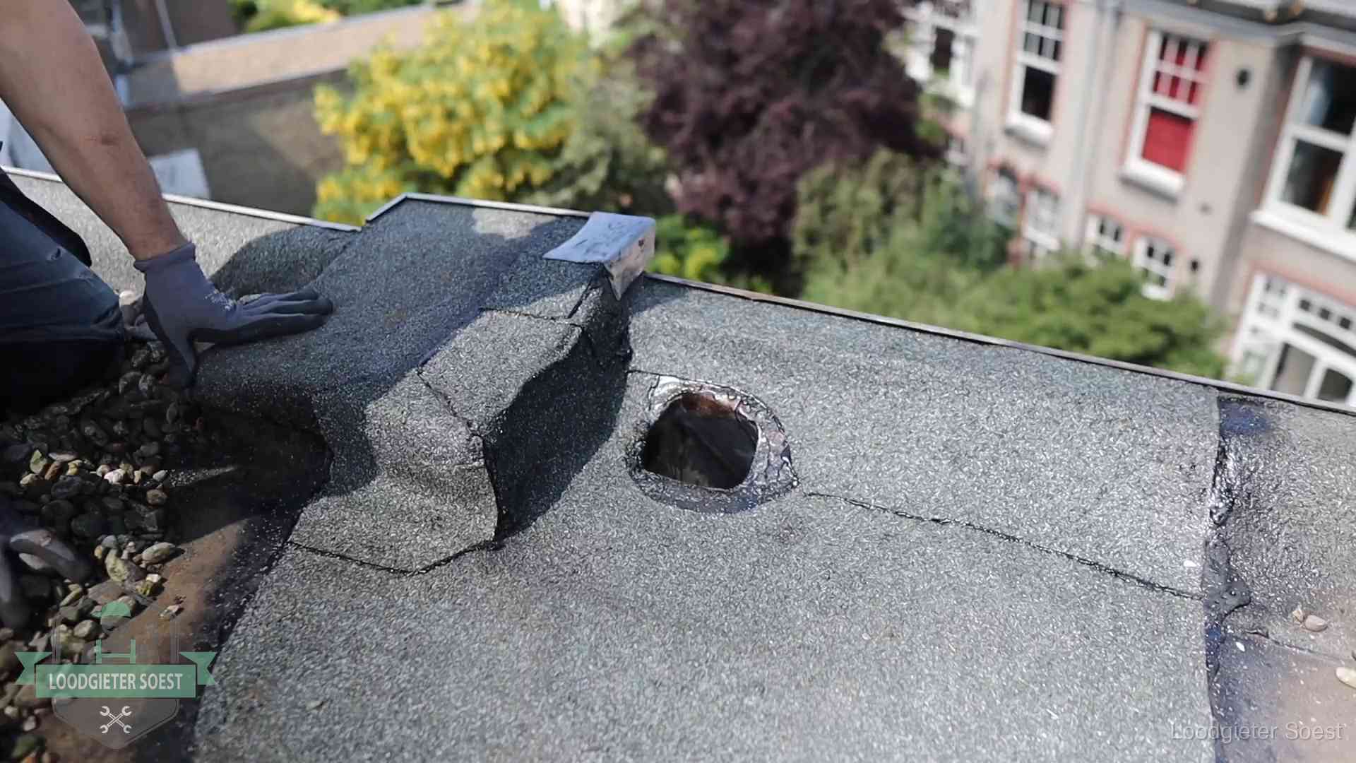 Loodgieter inspecteert een beschadigd bitumen plat dak tijdens een daklekkage-inspectie in Soest