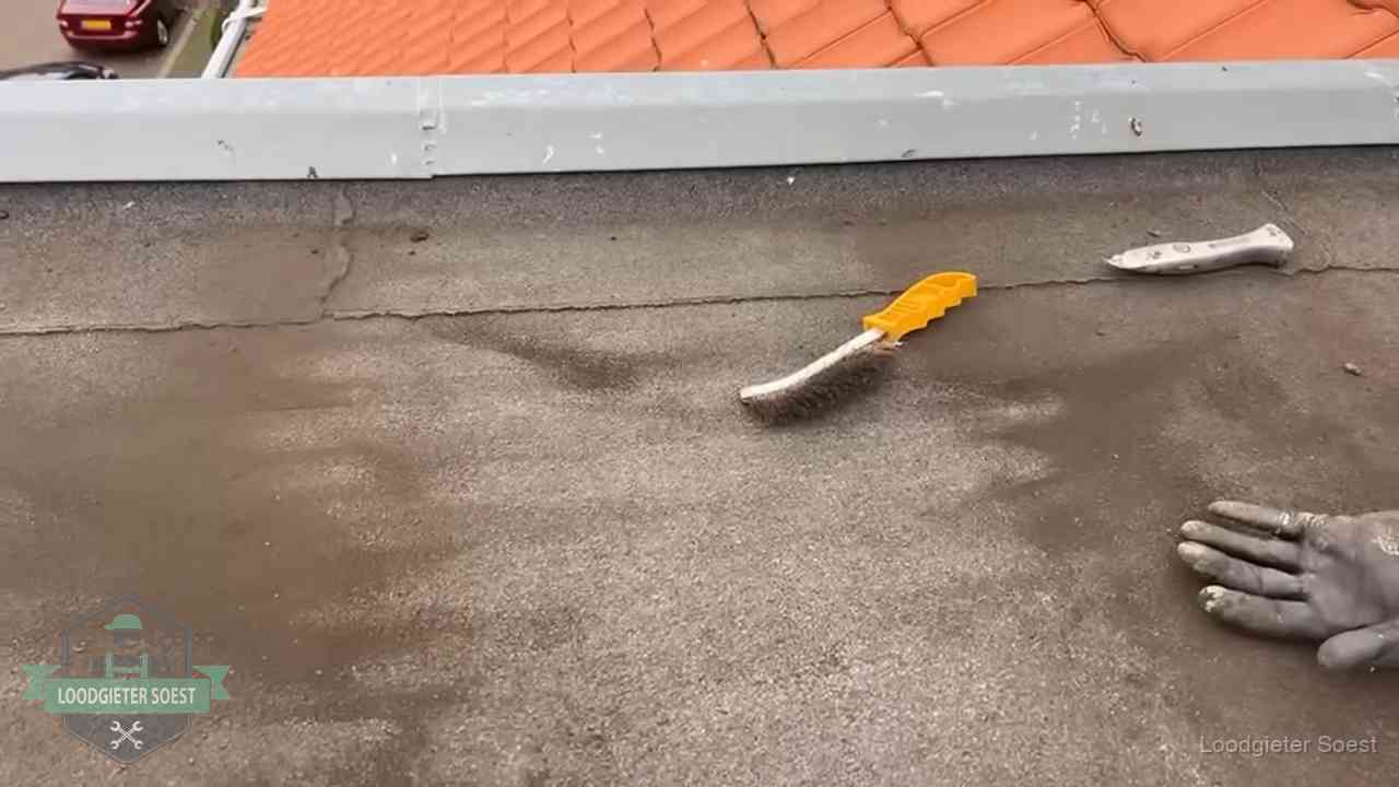 Dakdekker bereidt een bitumen plat dak voor op reparatie bij de daktrim in Soest