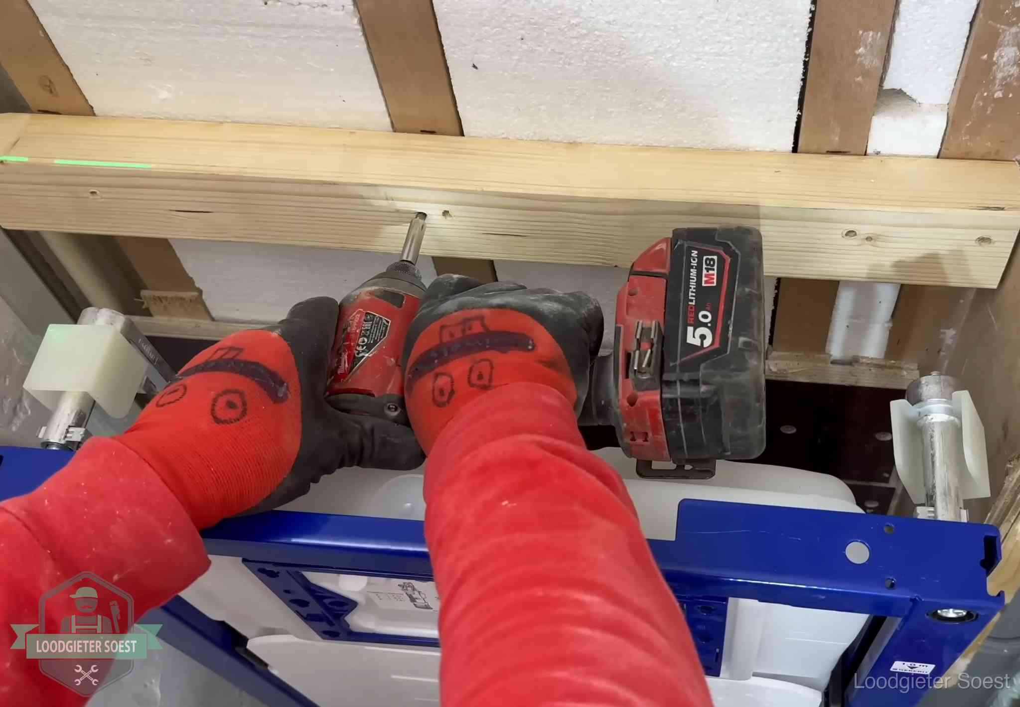 Monteur bevestigt een inbouwreservoir voor een hangend toilet in Soest