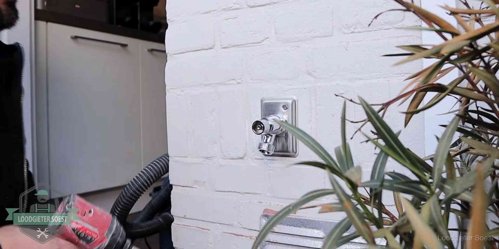 Chromen kraan op een muurplaat bij een woning in Soest, dichtdraaien is stap een van de lektest