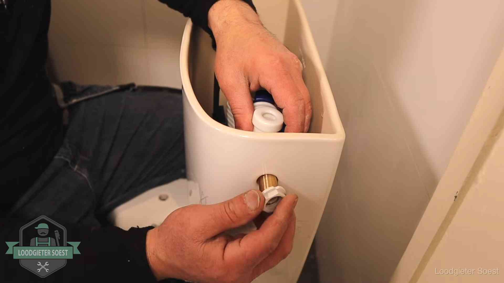 Loodgieter monteert de vlotterkraan van een stortbak bij een toilet in Soest