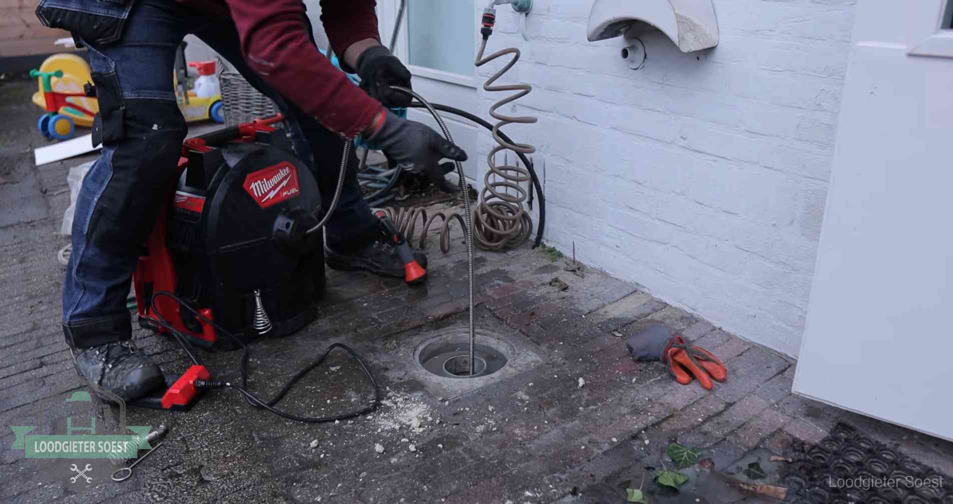 Erfgrens en gemeenteriool in Soest Ontstoppingsputje in de bestrating naast de gevel van een woning in Soest