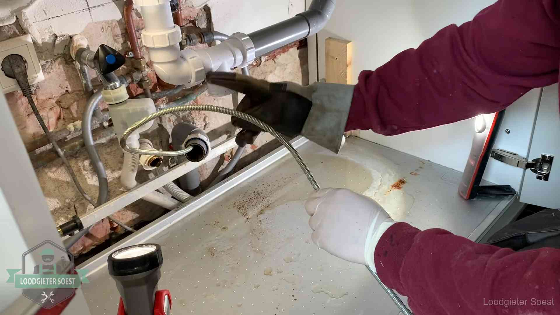Spiraal of hogedruk in Soest Ontstoppingsveer gaat in een geopende sifonaansluiting onder het aanrecht in Soest