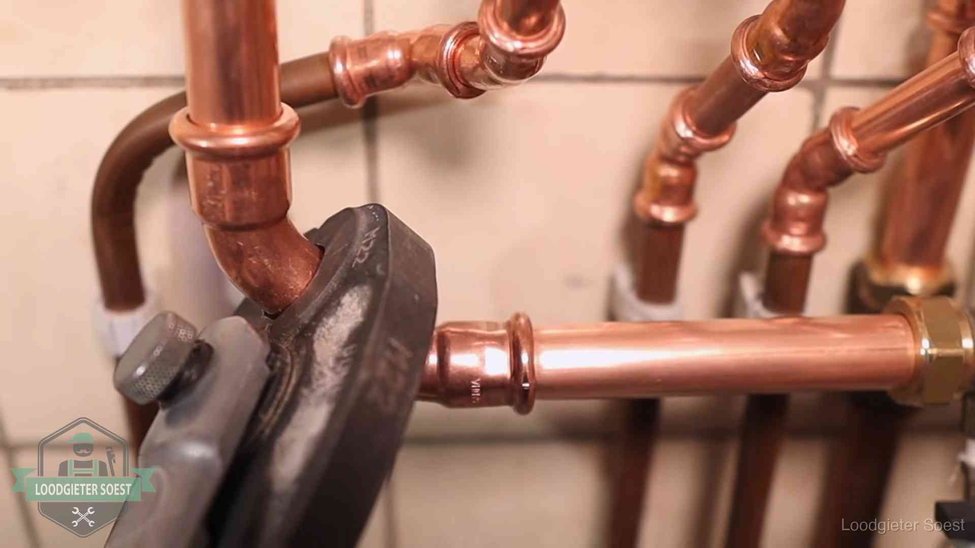 Werkwijze van ons loodgietersbedrijf in Soest Persmachine perst een koperen fitting op nieuw leidingwerk in Soest