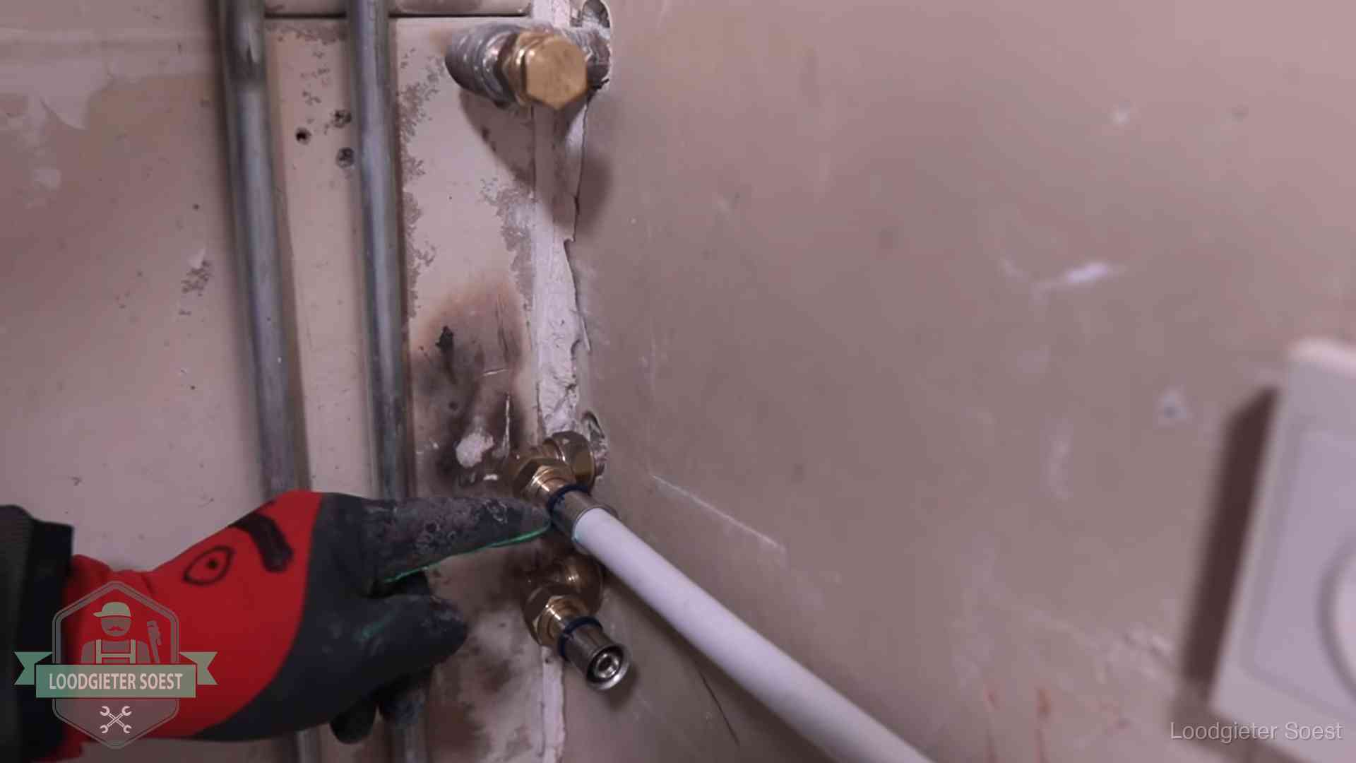 Garantie op loodgieterswerk in Soest Loodgieter wijst de persfitting op nieuwe muuraansluitingen aan in een woning in Soest