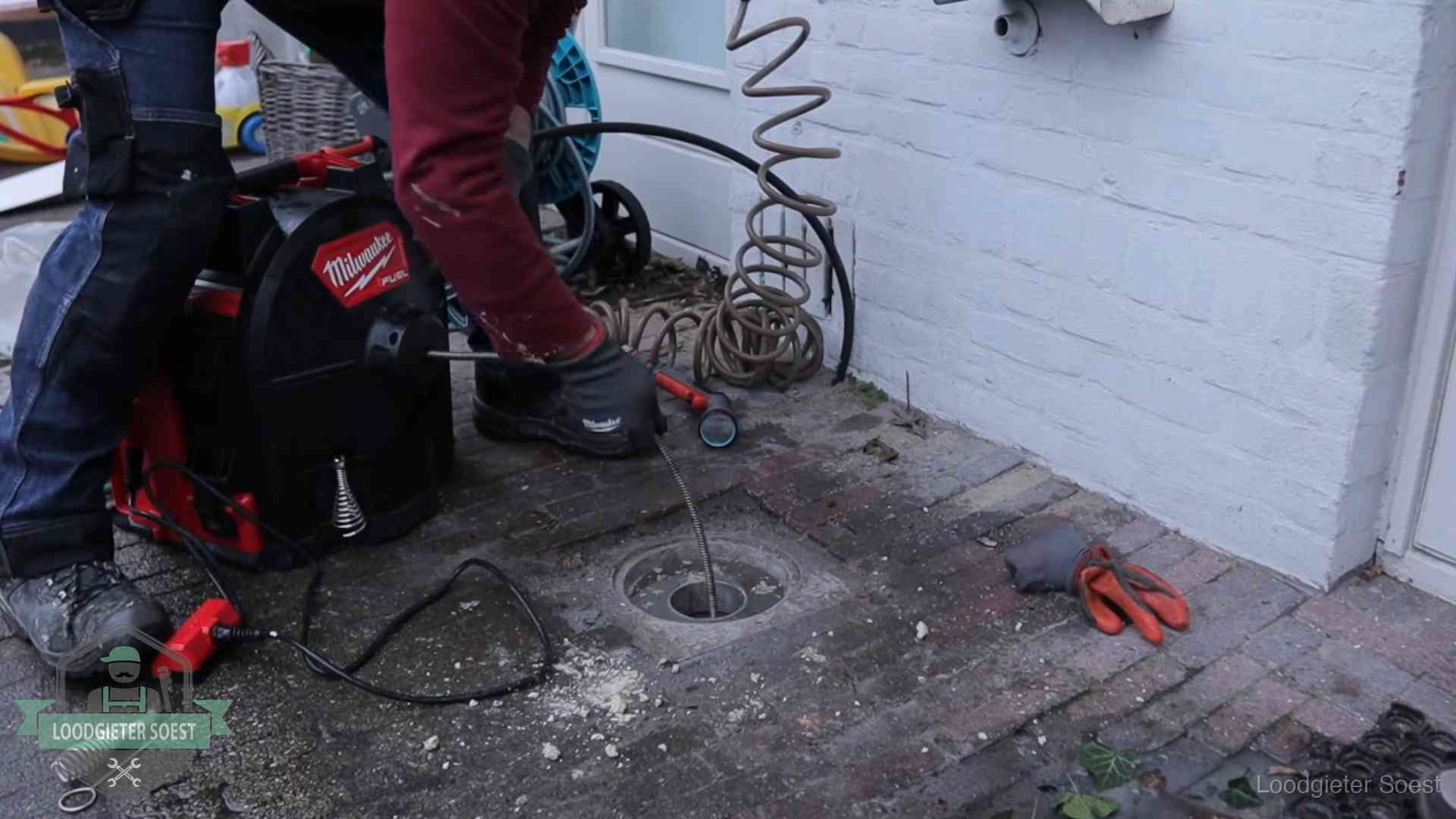 Prijs van een rioolontstopping in Soest Spiraalmachine bij een ontstoppingsputje in de bestrating in Soest