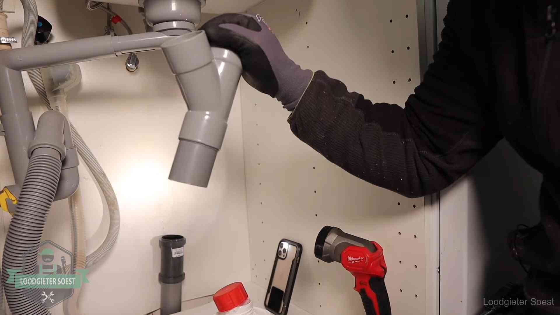 Rioollucht in huis verhelpen in Soest Loodgieter demonteert het sifon- en afvoerwerk onder een gootsteen in Soest bij stankklachten