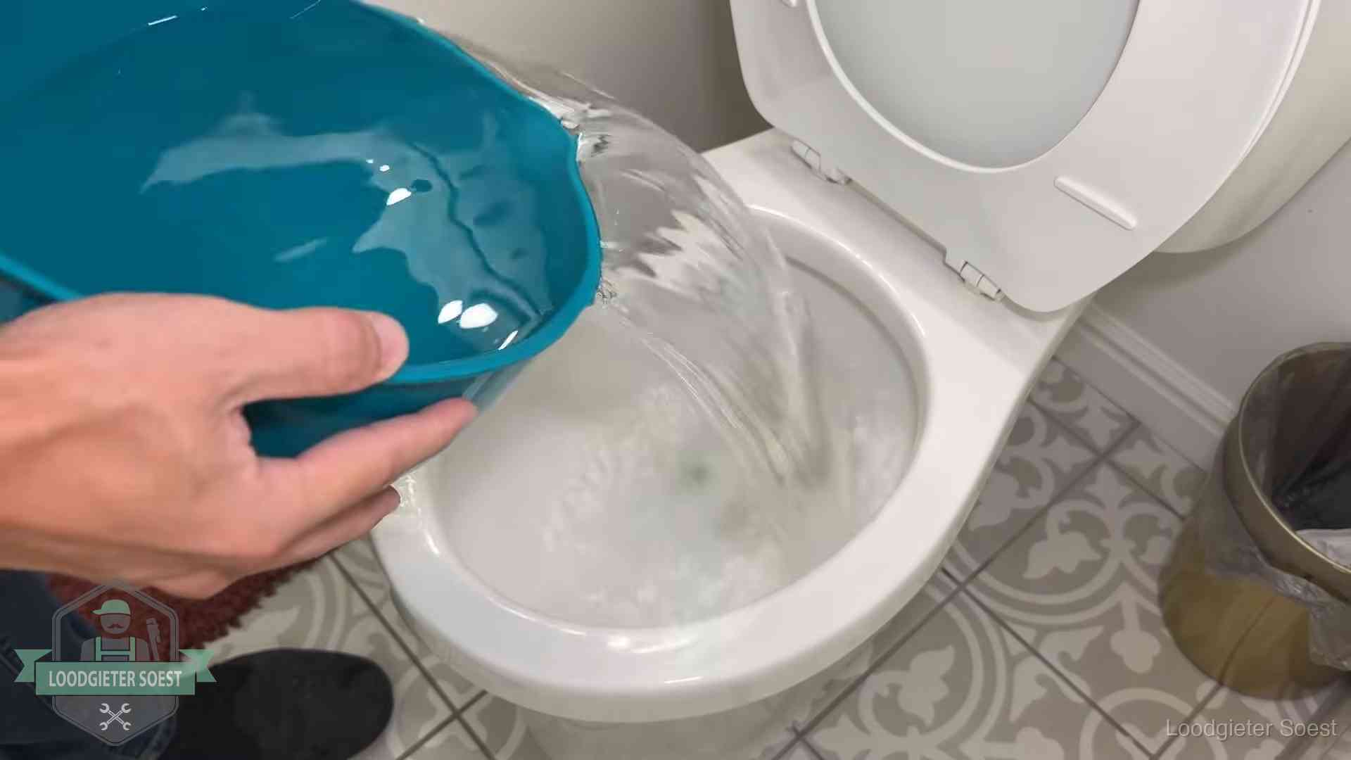 Warm water wordt voorzichtig in de wc-pot gegoten in Soest