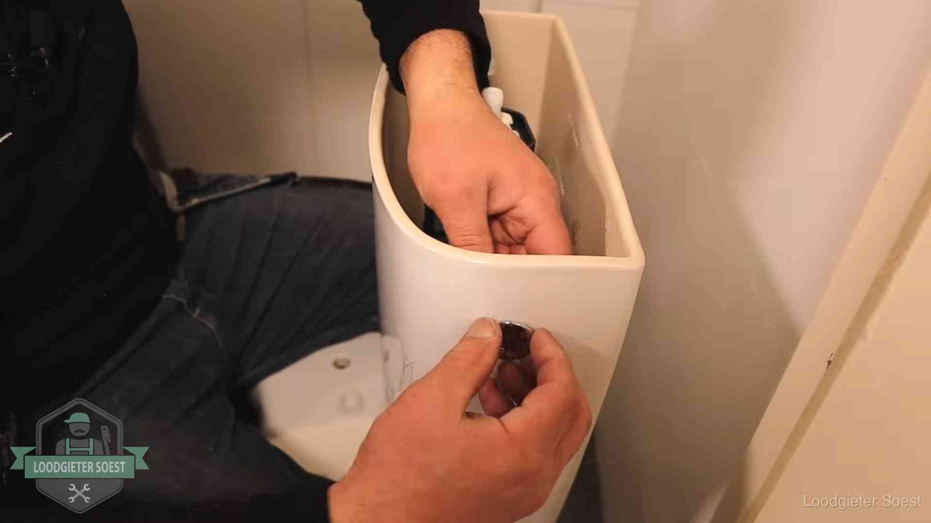 Drukknop van een duoblok-stortbak wordt gemonteerd bij een toilet in Soest