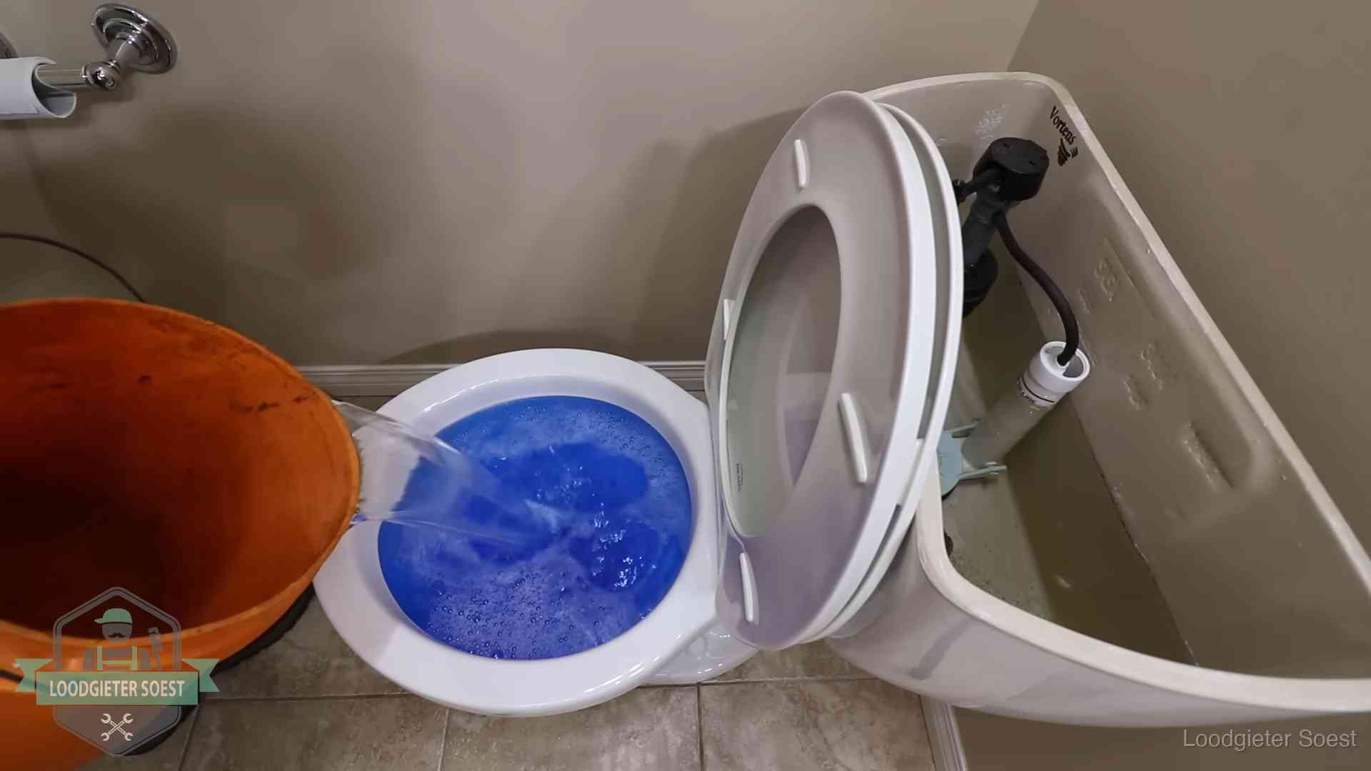 Water bij de wc-pot wordt met een emmer weggewerkt om schade te beperken in Soest